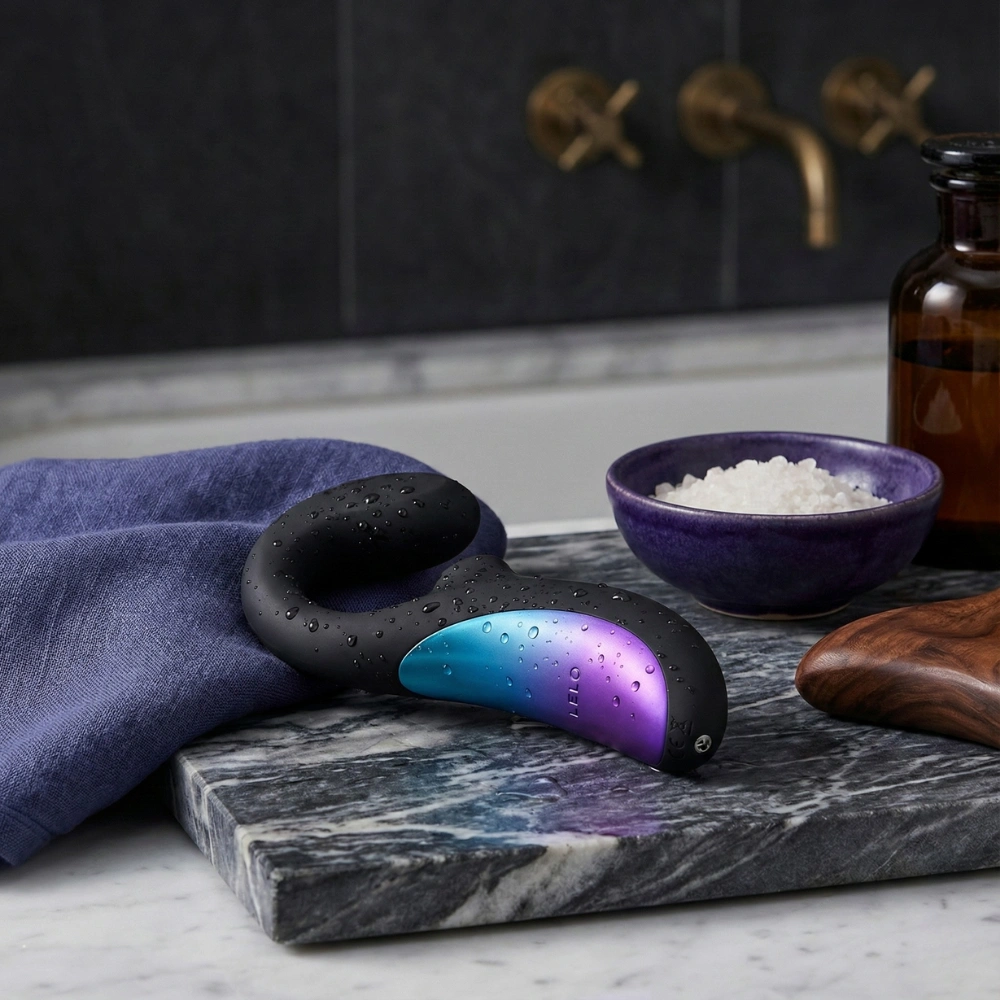 Masseur sonique étanche Lelo Enigma Wave posé sur un plan de travail en marbre noir.