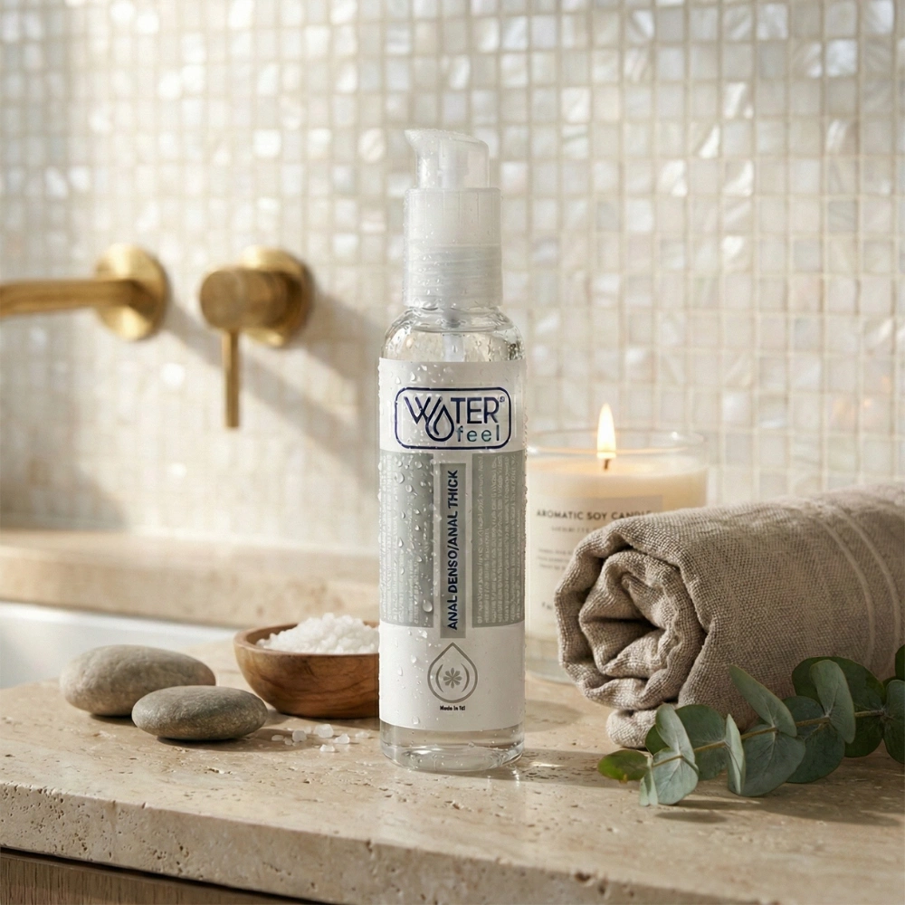 Lubrifiant anal de haute qualité Waterfeel à côté d'une bougie pour une ambiance zen.