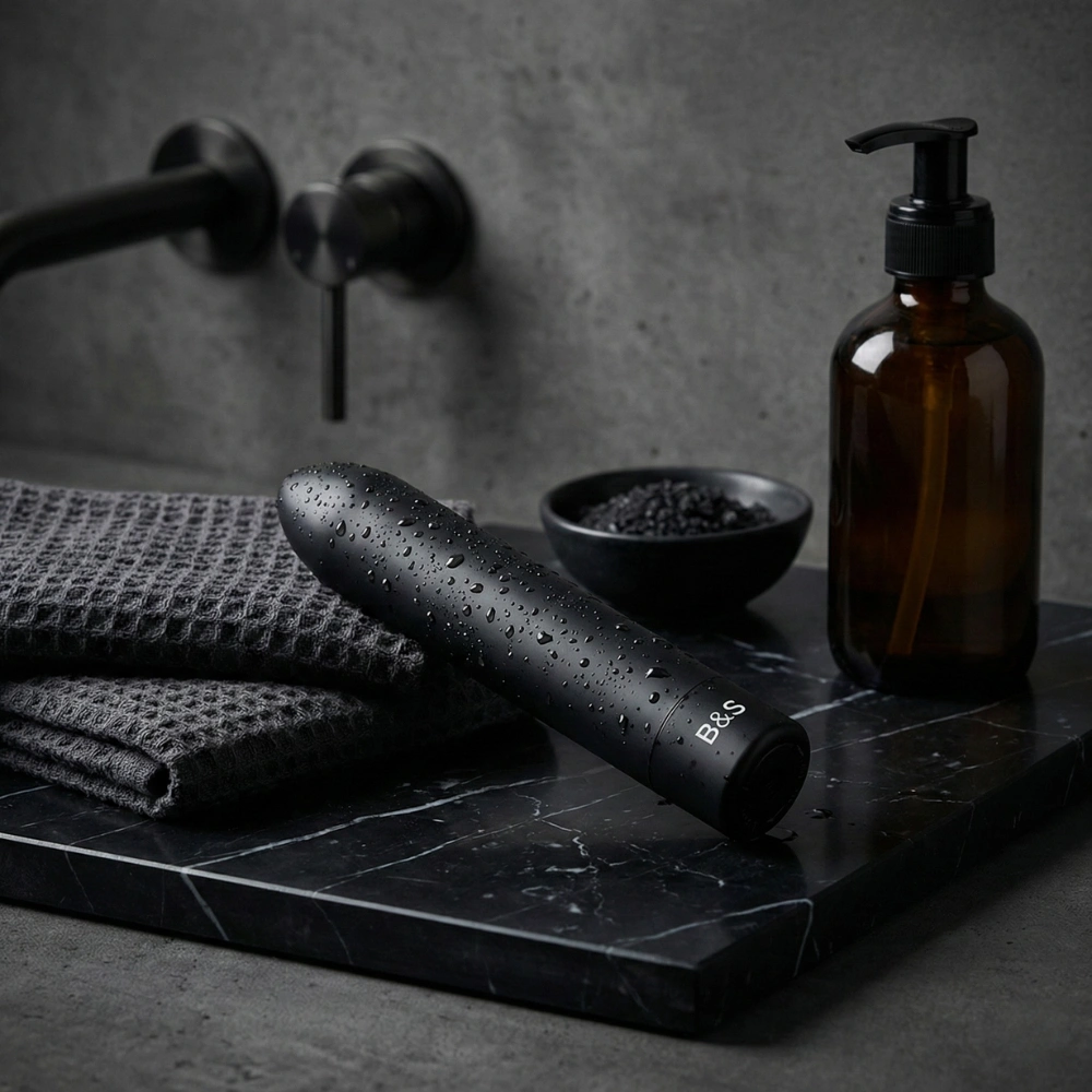 Mini bullet vibrant étanche posé sur un plan de travail en marbre noir.