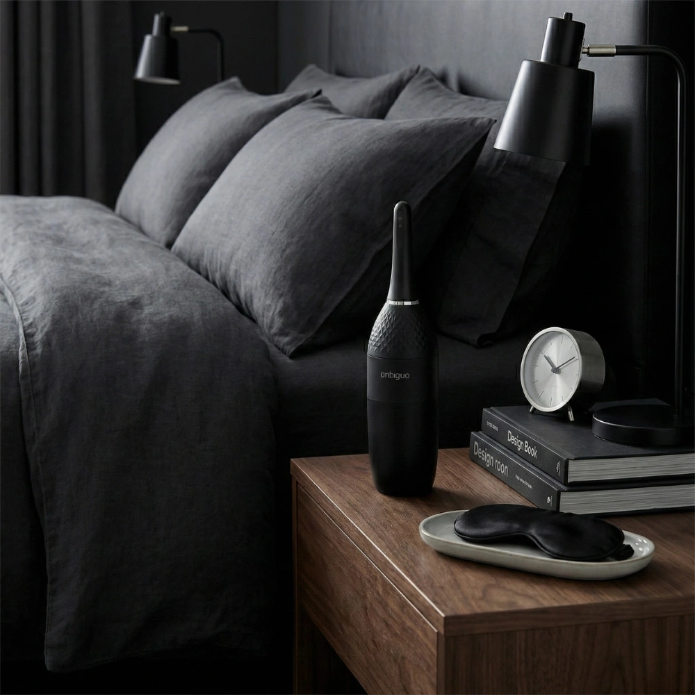 Accessoire d'hygiène anale Ambiguo au design discret sur une table de nuit moderne.